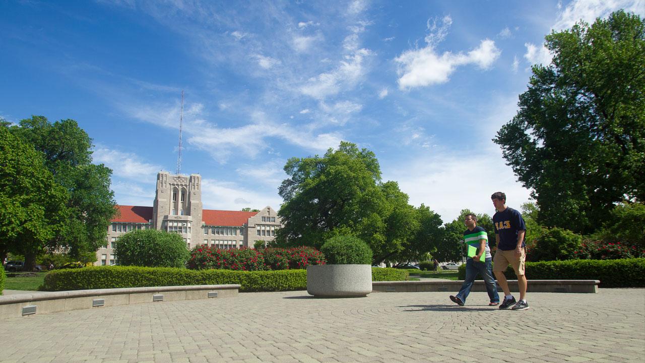 Two students walking across campus