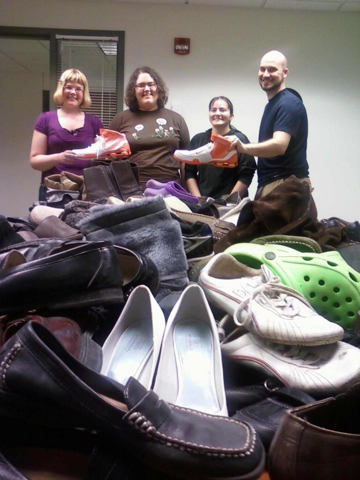 Pi Gamma Mu students with pile of shoes